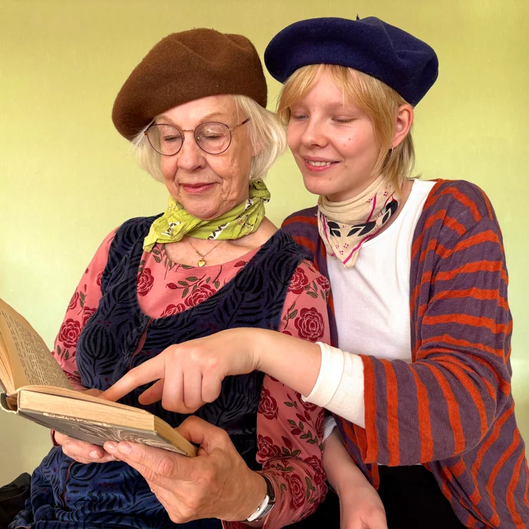 Twee vrouwen gekleed in Parijs-geïnspireerde kleding, zoals baretten en gestreepte truien.