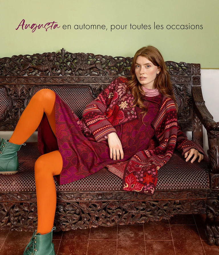 A woman wearing a red dress and patterned cardigan from Gudrun Sjödén.