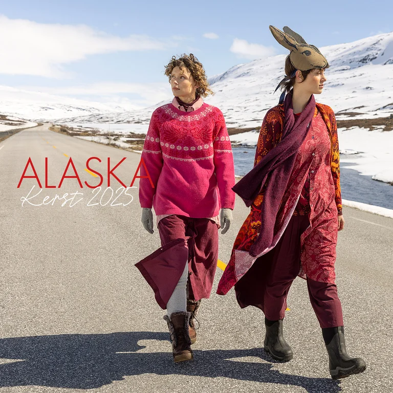 Twee vrouwen die op een weg in een sneeuwlandschap lopen en kleding dragen uit de kerstcollectie 2025 van Gudrun Sjödén.