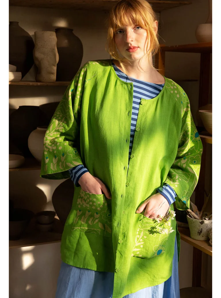 A woman in a green “Nemorosa” linen tunic from Gudrun Sjödén.