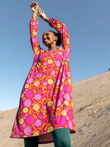 A woman wearing a colorful floral dress from Gudrun Sjödén.