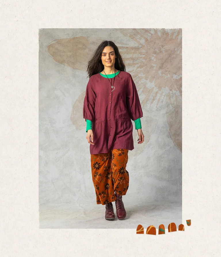 A woman wearing a solid-colour tunic and patterned trousers from Gudrun Sjödén.
