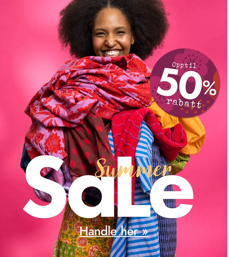 A woman with her arms full of colourful clothes from Gudrun Sjödén.