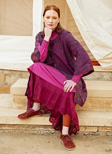 Two women wearing reddish purple clothes from Gudrun Sjödén.