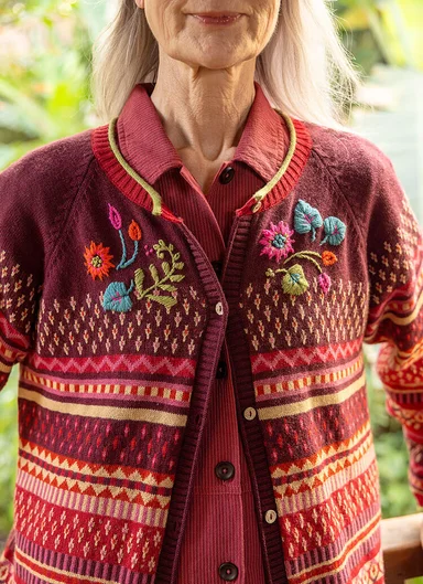 A woman wearing a patterned knitted cardigan from Gudrun Sjödén.