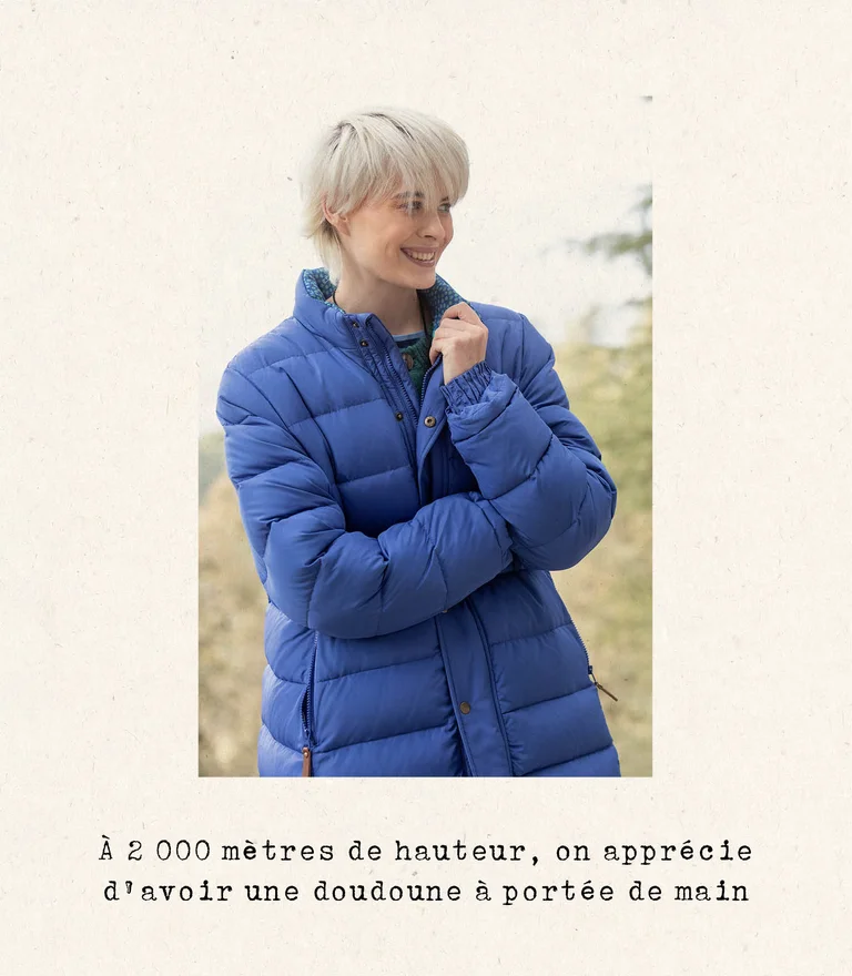 A woman wearing a blue down coat from Gudrun Sjödén.
