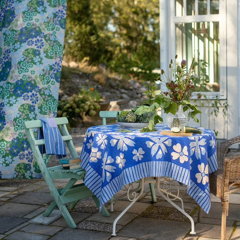Een terras met woontextiel in blauwe tinten van Gudrun Sjödén.