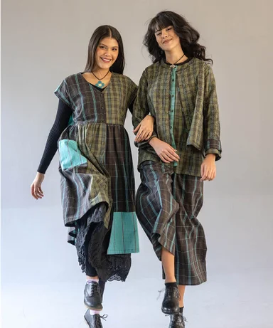 Two women with arms linked wearing striped woven clothes from Gudrun Sjödén.