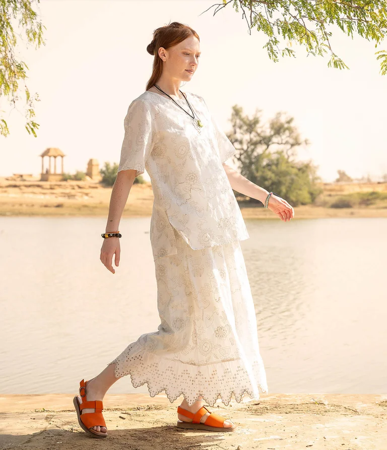 A woman wearing an embroidered blouse and skirt from Gudrun Sjödén.