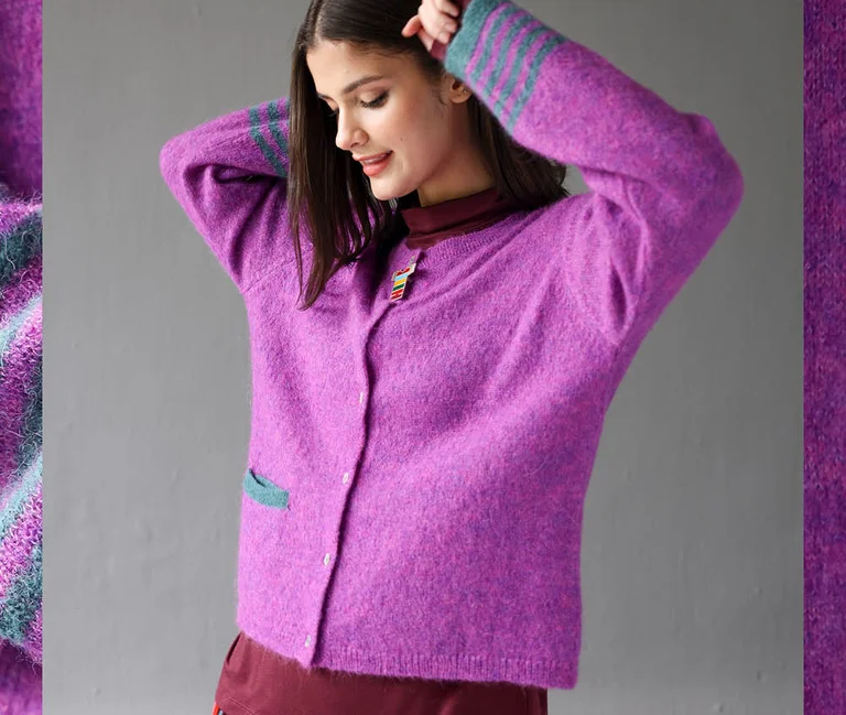 A woman wearing a purple, knitted cardigan from Gudrun Sjödén. 
