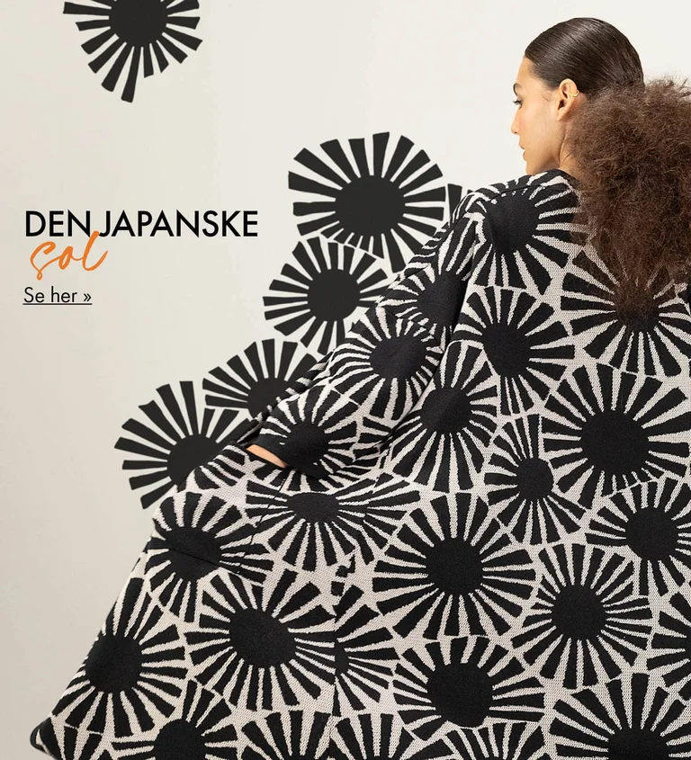 En kvinde med ryggen til kameraet, iført en lang cardigan med mønster af sorte, grafiske sole fra Gudrun Sjödén. Mønsteret er blevet forlænget på billedet, så det ser ud som om, det flyder ud fra cardiganen.
