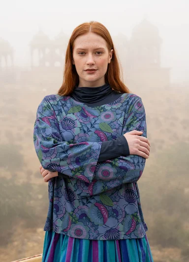 A woman wearing a striped blouse and skirt from Gudrun Sjödén.