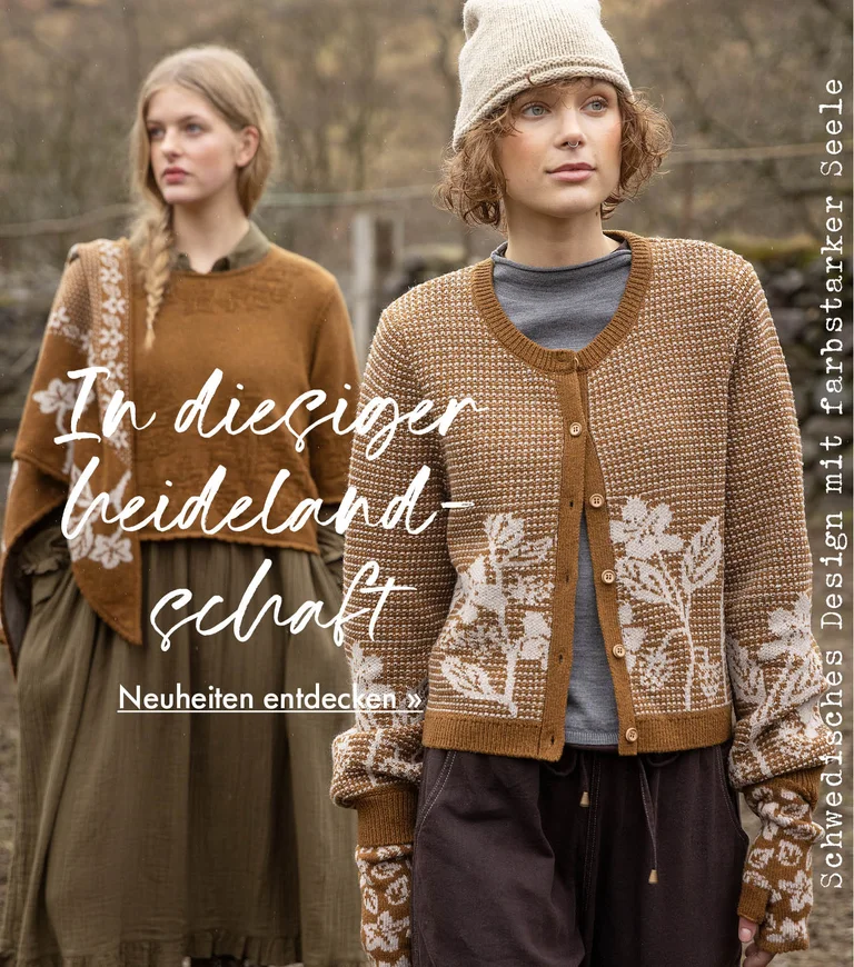 Two women standing next to each other wearing clothes in earthy hues from Gudrun Sjödén. Sheep and a stone wall are visible in the background.