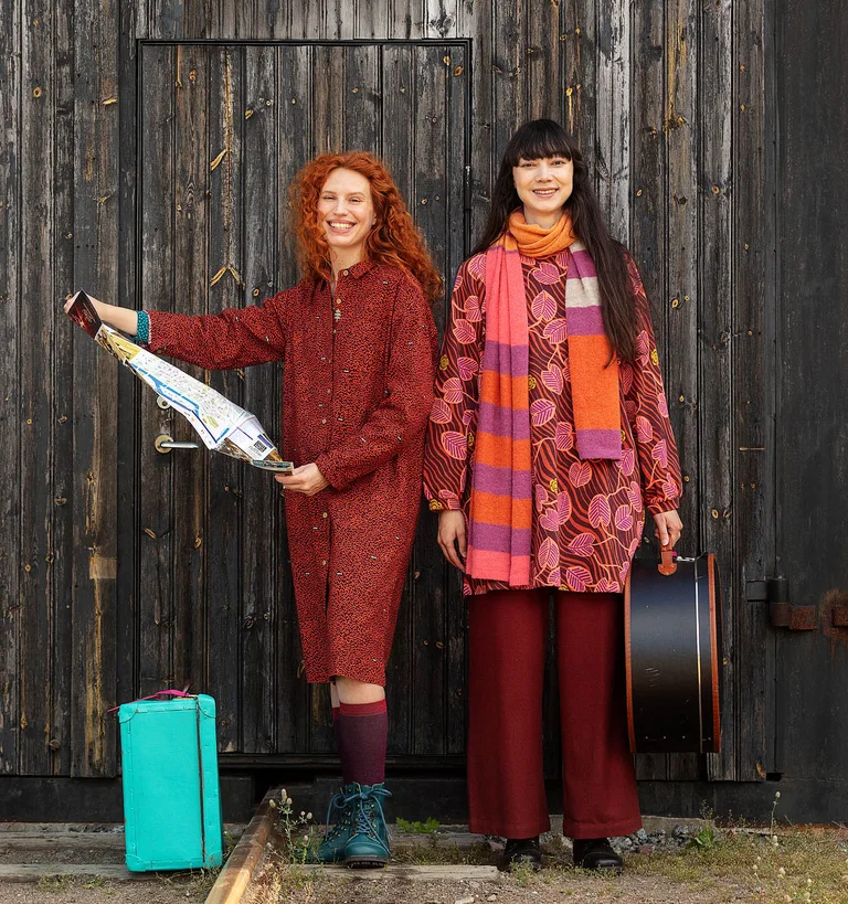 Twee vrouwen naast elkaar die een kaart lezen in kleding van Gudrun Sjödén.