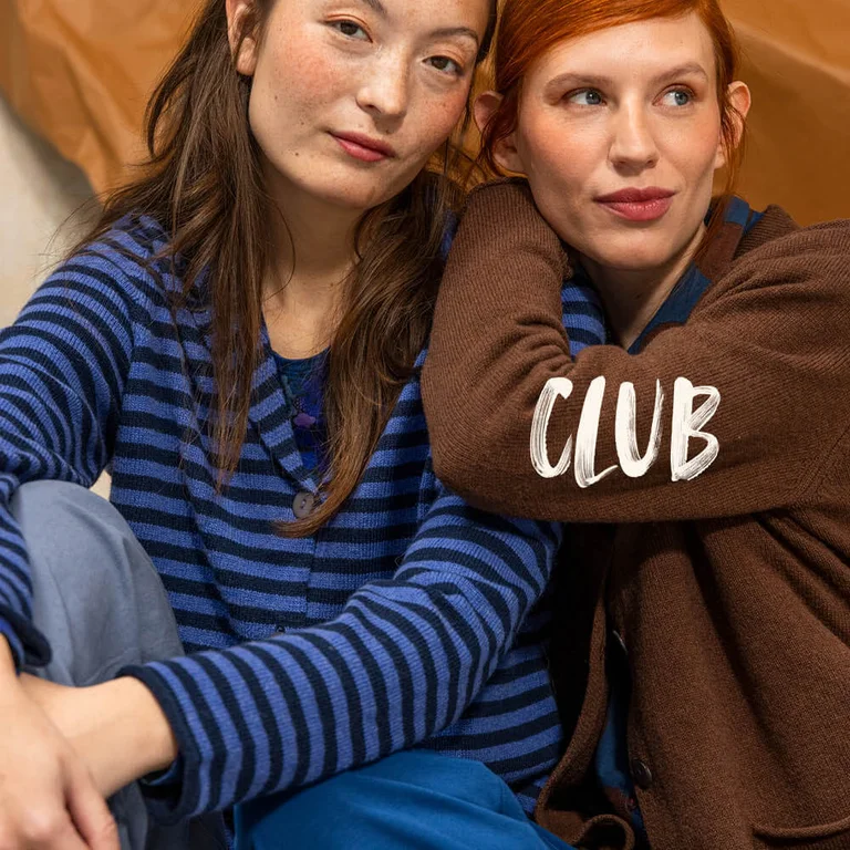 Deux femmes serrées l'une contre l'autre, chacune portant un blazer en maille signé Gudrun Sjödén.