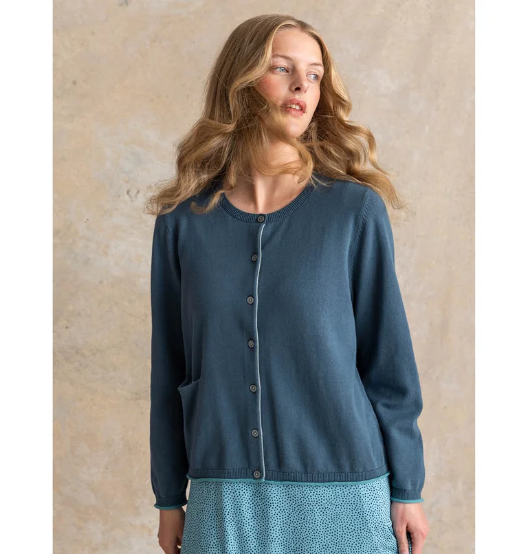 A woman wearing a blue cardigan from Gudrun Sjödén’s Essentials collection.