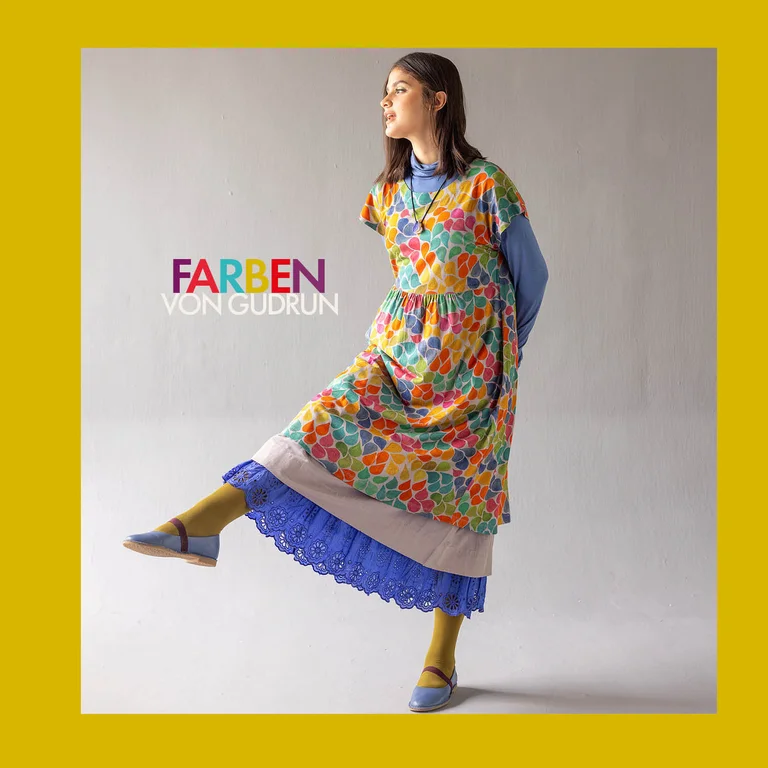 Eine auf einem Bein stehende Frau im Lagenlook aus Gudrun Sjödéns Paris-Kollektion.