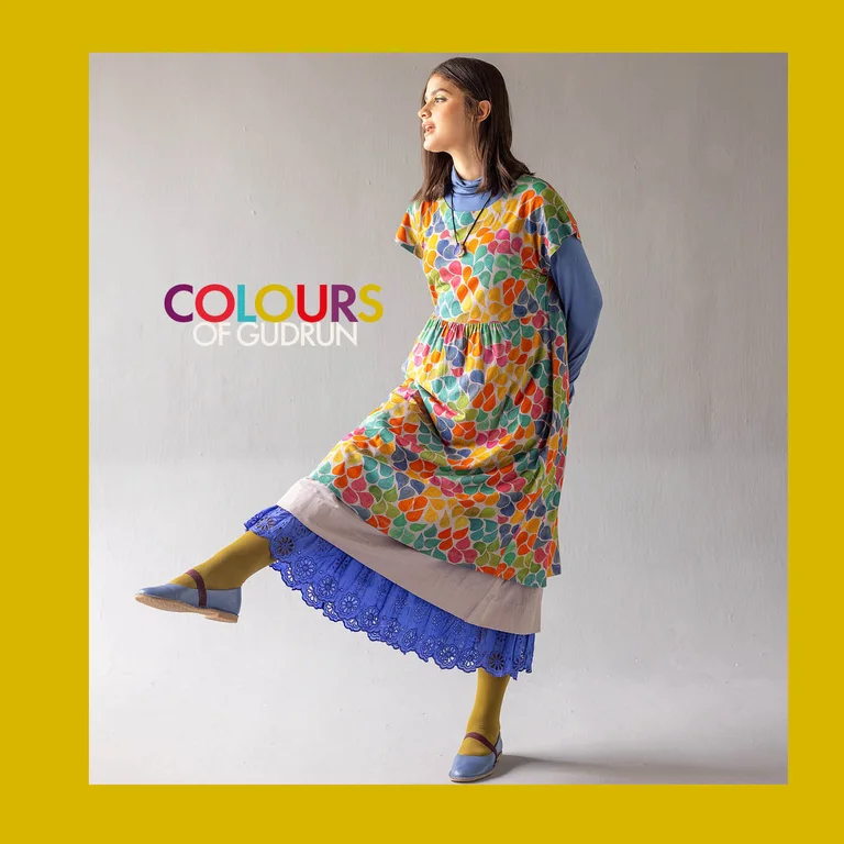 A woman posing on one leg wearing layers of clothes from Gudrun Sjödén’s Paris collection.