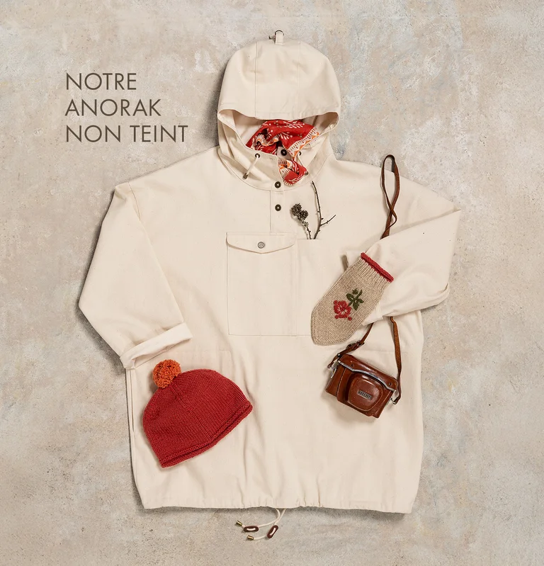 Une composition avec un anorak blanc et des accessoires assortis signés Gudrun Sjödén.