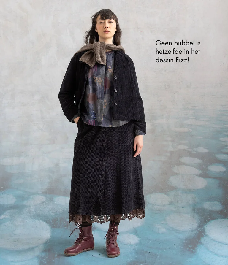Een vrouw gekleed in een jack en rok van corduroy van Gudrun Sjödén.