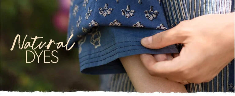 A hand pulling down a blue, patterned sleeve of a block-printed top from Gudrun Sjödén.