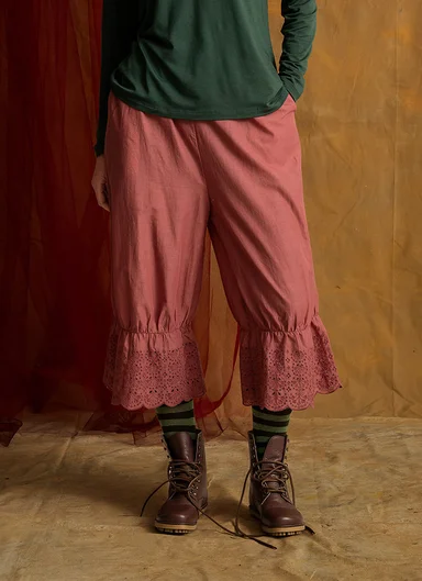 A woman wearing a pair of pants with an eyelet-embroidered lace edge from Gudrun Sjödén.