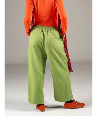 A body facing away from the camera wearing a pair of light green trousers from Gudrun Sjödén.