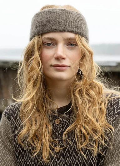 A woman wearing a knitted scarf and beanie from Gudrun Sjödén.