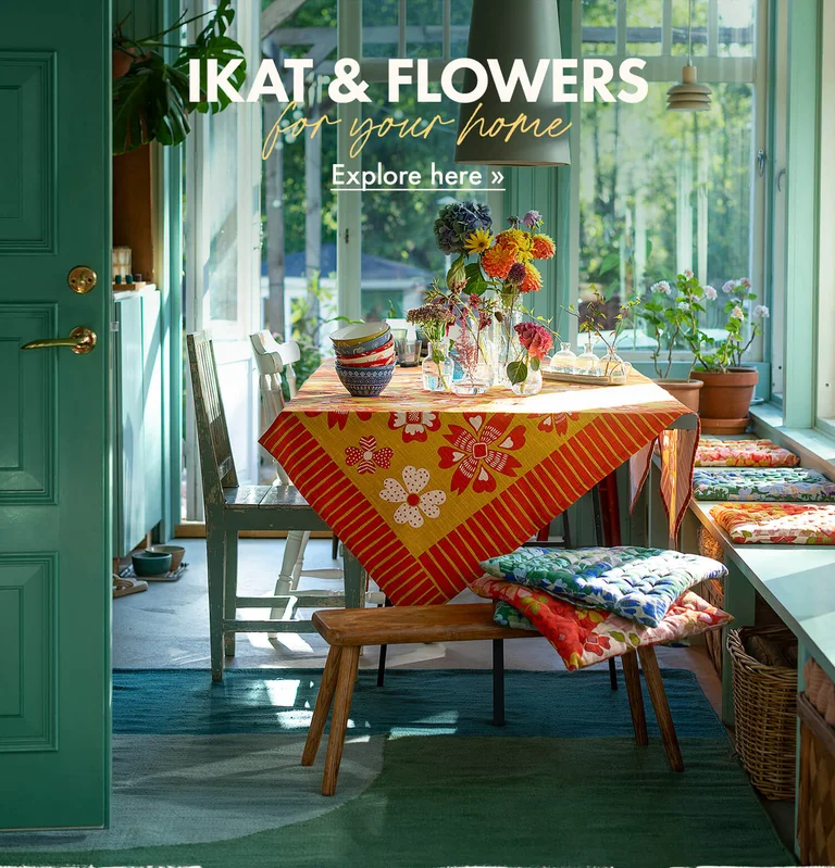 A table laid with colourful home textiles from Gudrun Sjödén.