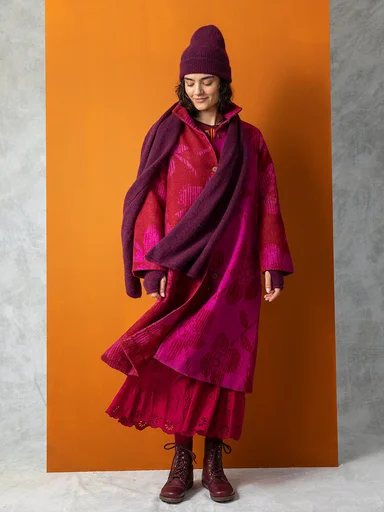 A woman wearing a coat and wool accessories from Gudrun Sjödén
