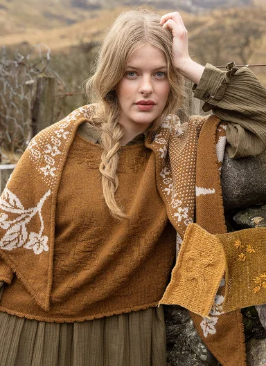 A close-up of a woman wearing clothes in earthy tones from Gudrun Sjödén.