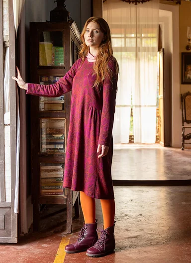 A woman wearing a red dress from Gudrun Sjödén.