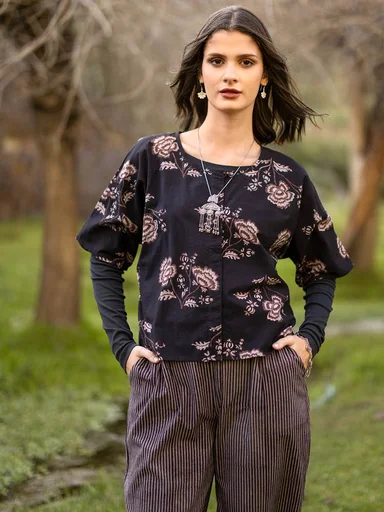 A woman wearing a patterned blouse from Gudrun Sjödén. 