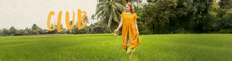 A woman wearing a yellow, embroidered dress from Gudrun Sjödén.