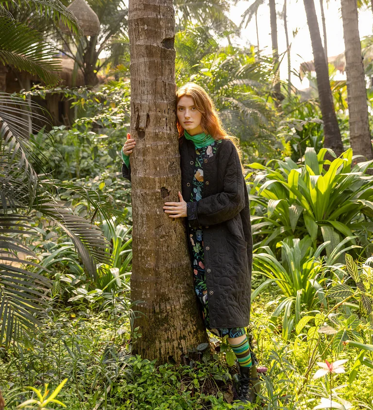 A woman wearing a jersey jacket and patterned dress from Gudrun Sjödén.