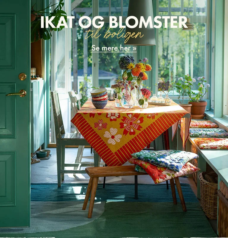 Et bord dækket med farverige boligtekstiler fra Gudrun Sjödén.