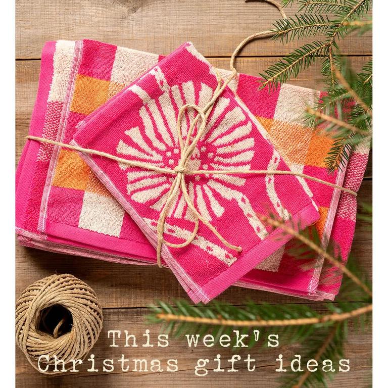 A pile of terry towels of varying sizes from Gudrun Sjödén, tied together with a gift ribbon.