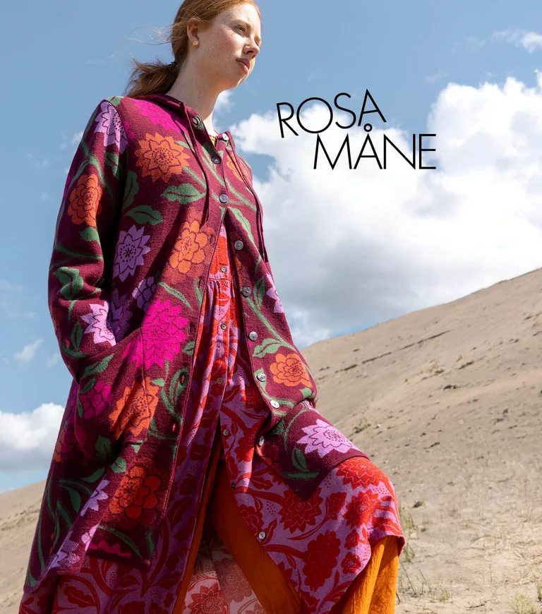 A woman wearing a floral dress and cardigan from Gudrun Sjödén. 