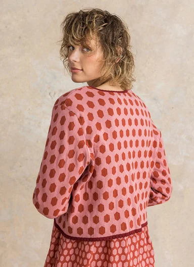 A woman wearing a dotted knitted cardigan from Gudrun Sjödén.