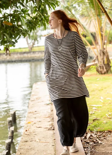 A woman wearing a black and white striped tunic from Gudrun Sjödén.