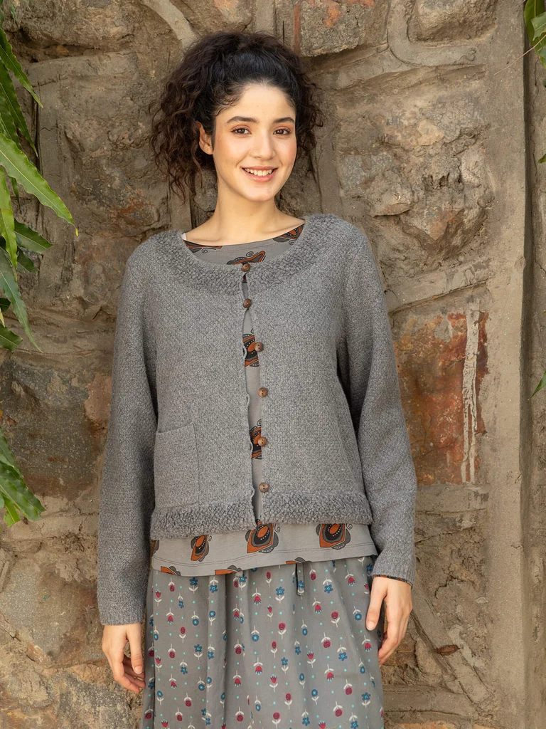 A woman wearing layers of gray clothing from Gudrun Sjödén.  
