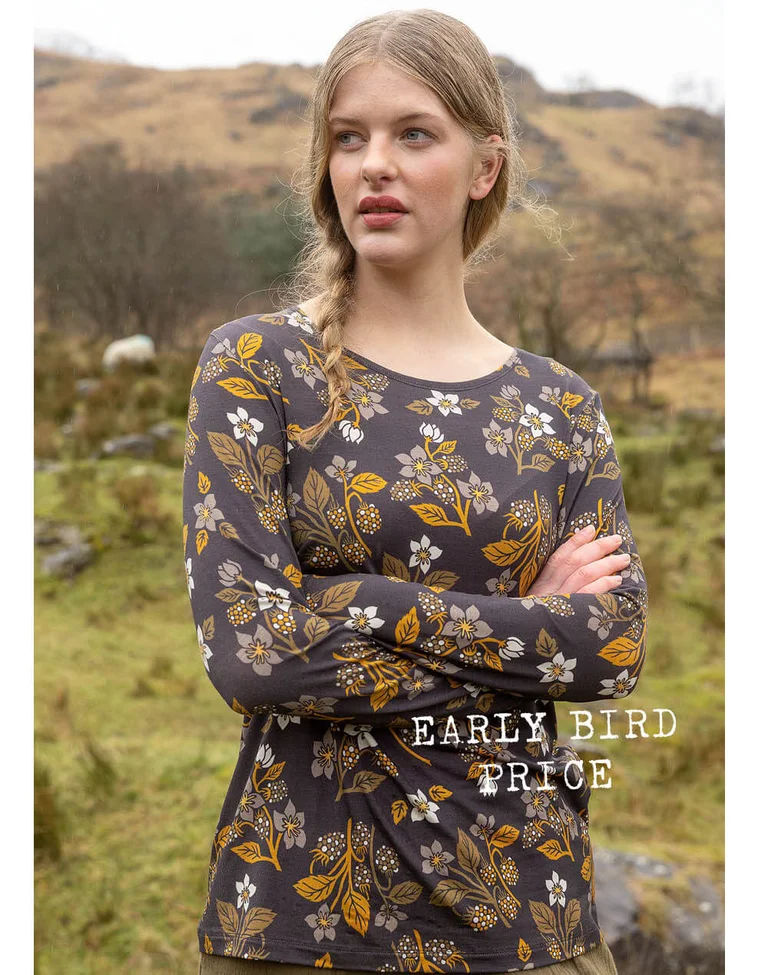 A woman wearing a patterned top from Gudrun Sjödén.