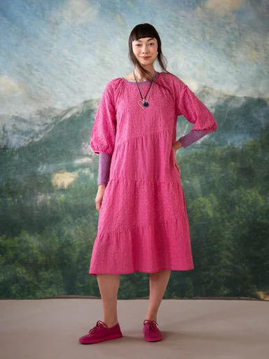 A woman wearing a pink dress from Gudrun Sjödén.