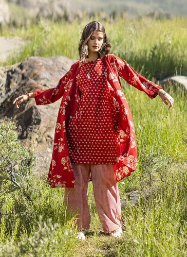 A close-up of the upper body of a woman wearing a striped woven garment from Gudrun Sjödén.