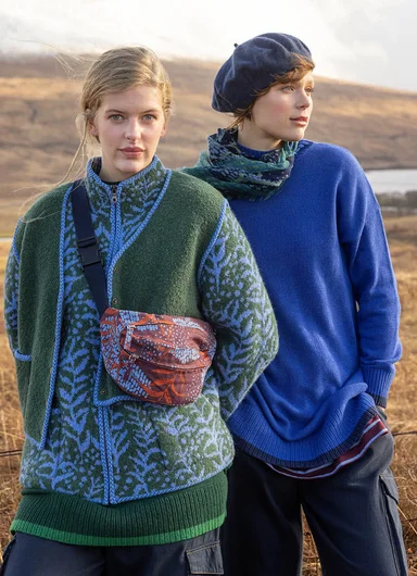A close-up of a woman wearing a red waistcoat and patterned scarf from Gudrun Sjödén.