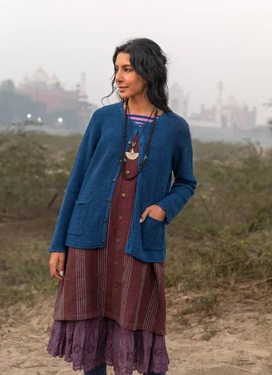 A woman wearing a burgundy knit sweater from Gudrun Sjödén.