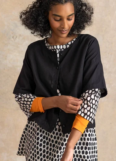 A woman wearing layers of black and white woven clothes from Gudrun Sjödén.