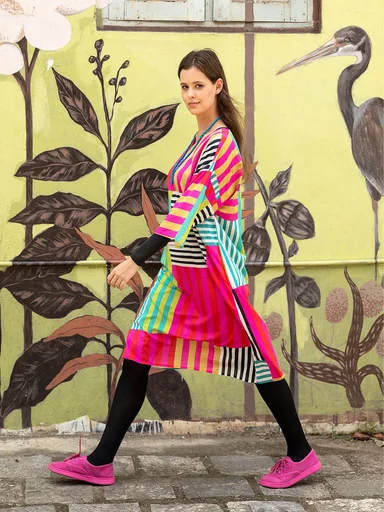 A woman wearing a colourful striped dress from Gudrun Sjödén.