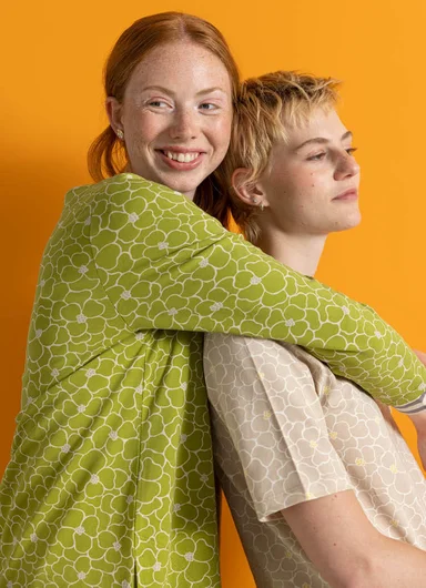Two women embracing, wearing jersey-fabric tops from Gudrun Sjödén.