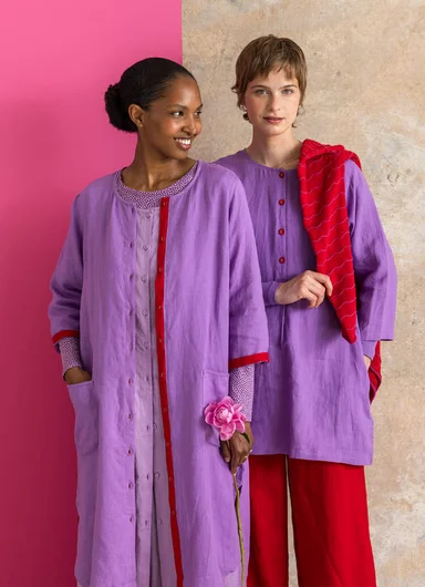 A woman in a studio wearing layers of woven clothes from Gudrun Sjödén.